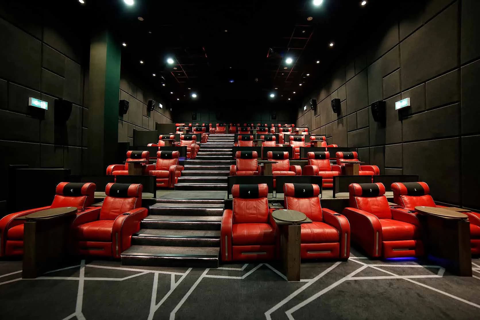 Wide view of a Flik Cinemas screen with tiered recliner seating