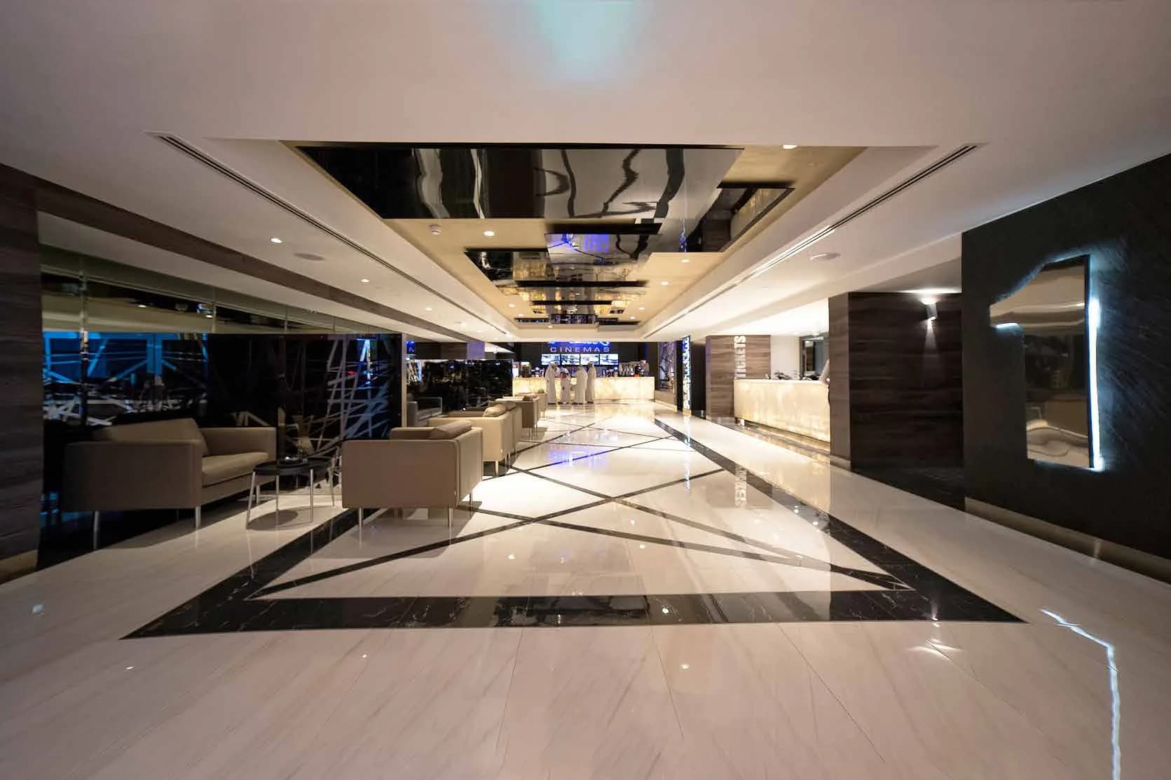 Flik Cinemas lobby with patterned marble flooring and lounge seating