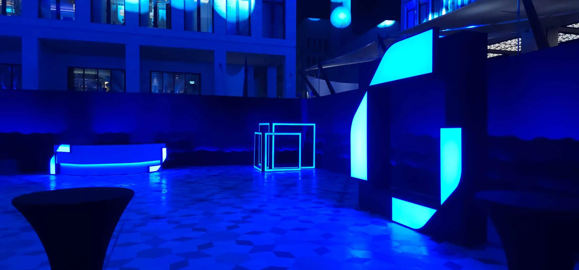 Blue-lit reveal installation with mirrored portals