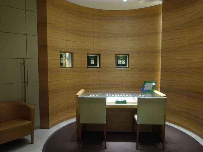Rolex showcase island beneath a curved timber-clad wall