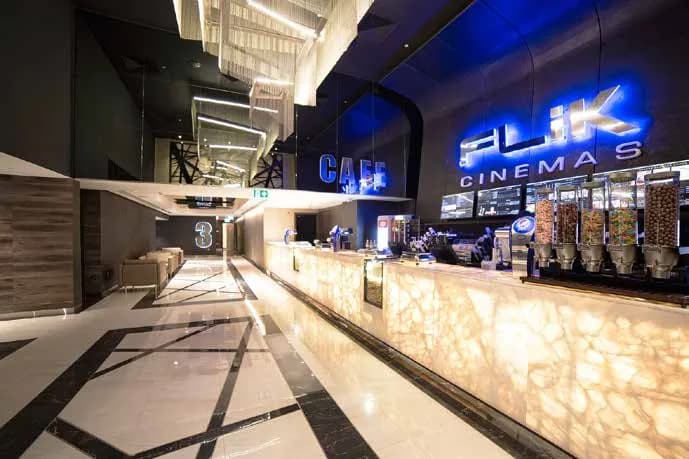 Flik Cinemas concession counter with backlit onyx and steel mesh ceiling